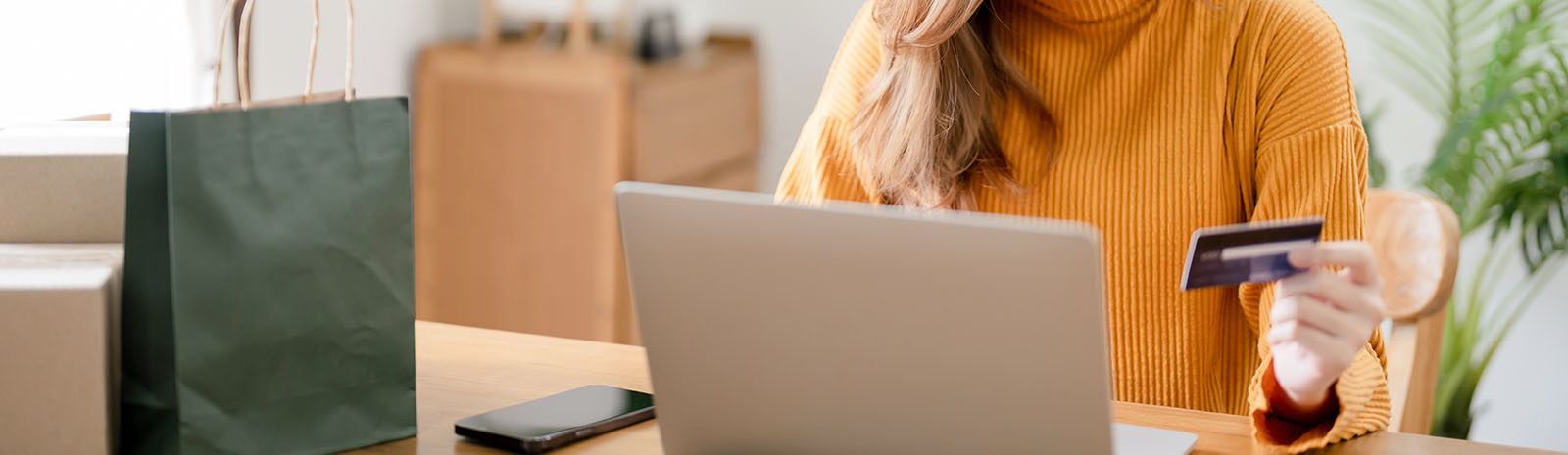 Woman holding credit card shopping online from home