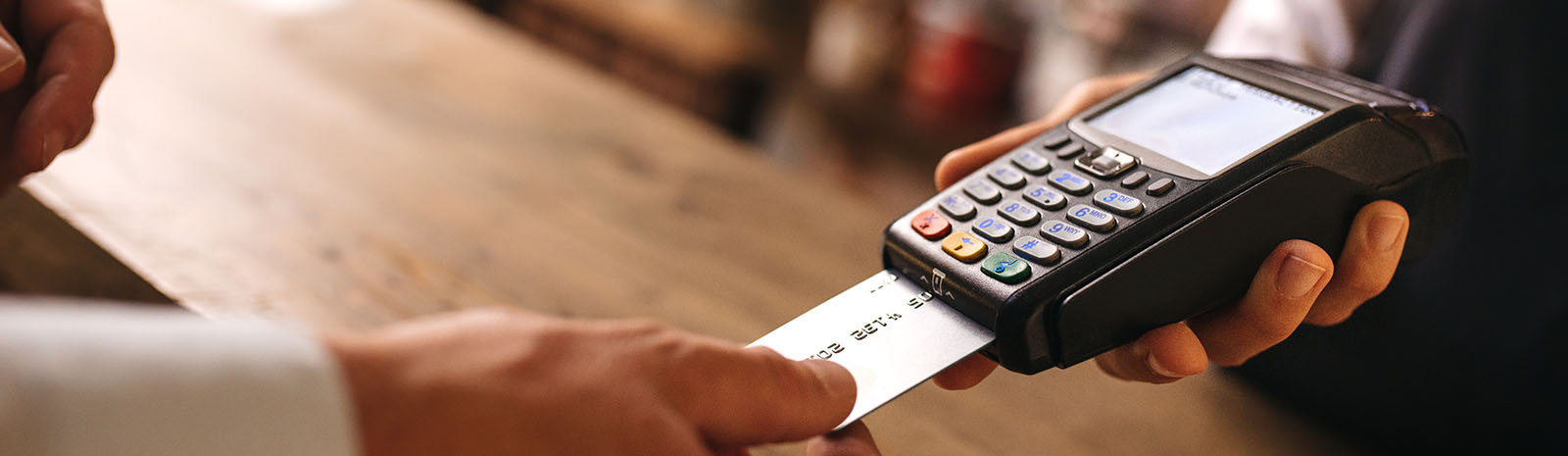 Hands inserting credit card into card machine