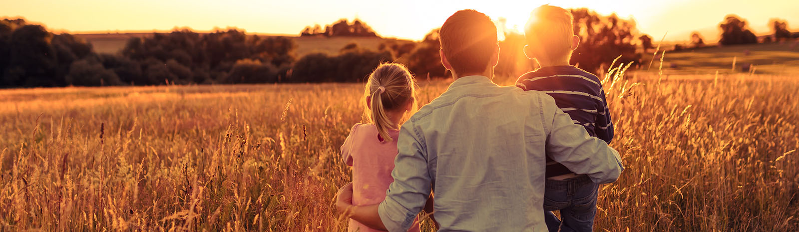 Family looking at sunset over the prairie